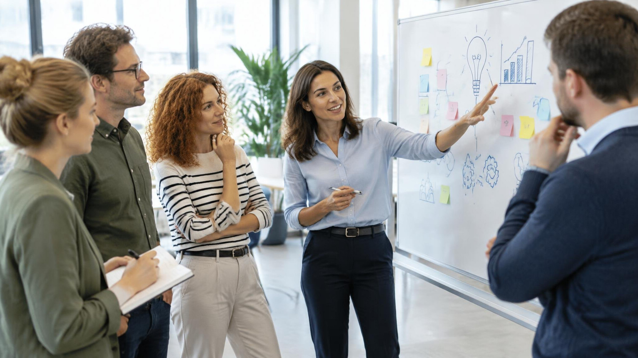 Professionals collaborating during a workshop session with a whiteboard